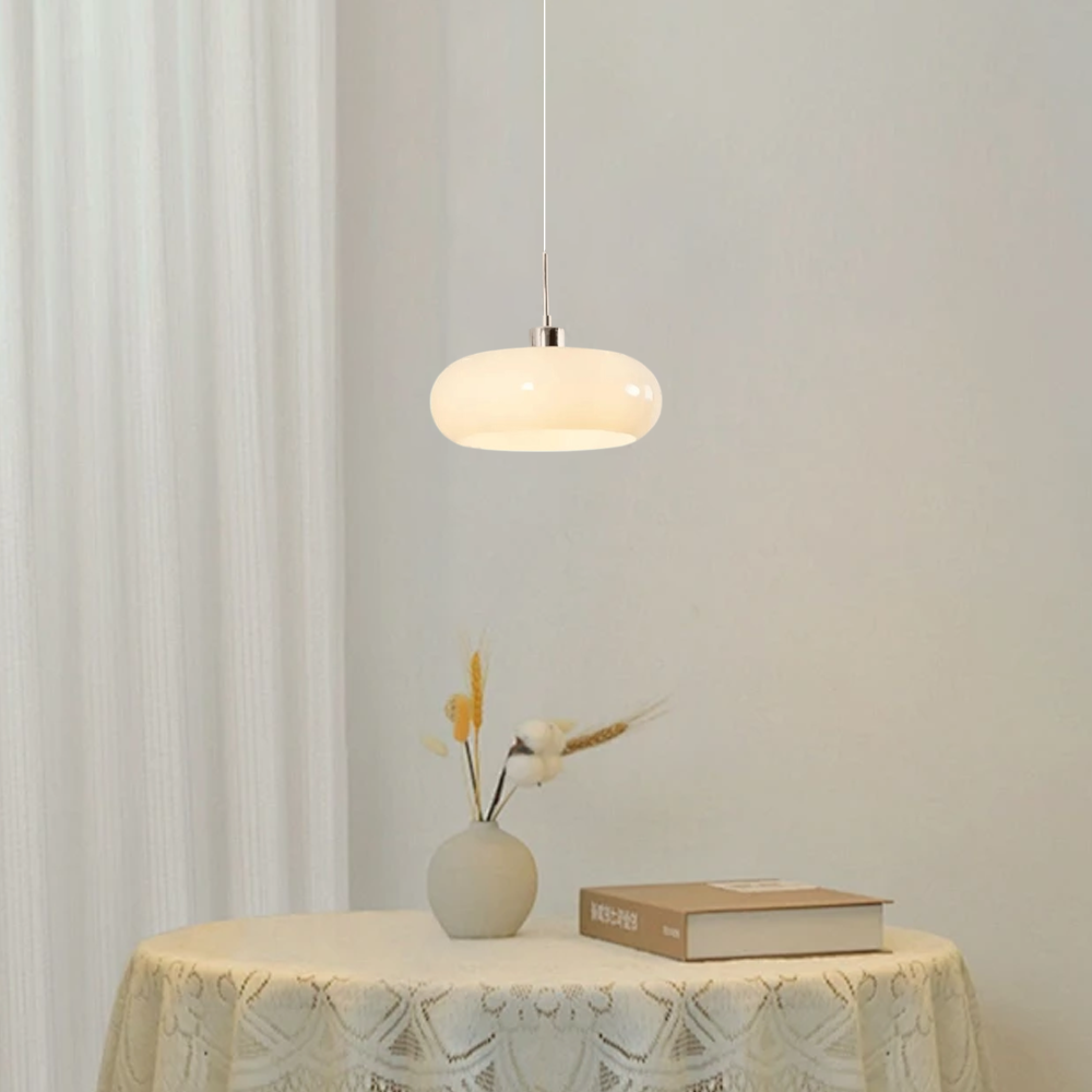 Weiße LED-Pendelleuchte schwebt über einem Holztisch in einem modernen offenen Essbereich