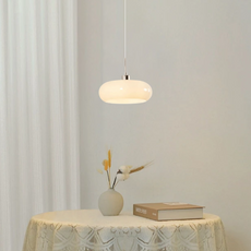 Weiße LED-Pendelleuchte schwebt über einem Holztisch in einem modernen offenen Essbereich