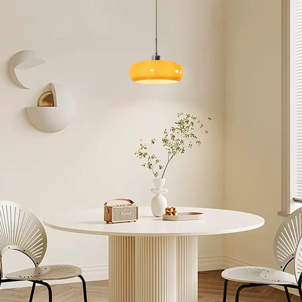 Stilvolle Pendelleuchte in Orange beleuchtet einen gedeckten Tisch im hellen Esszimmer