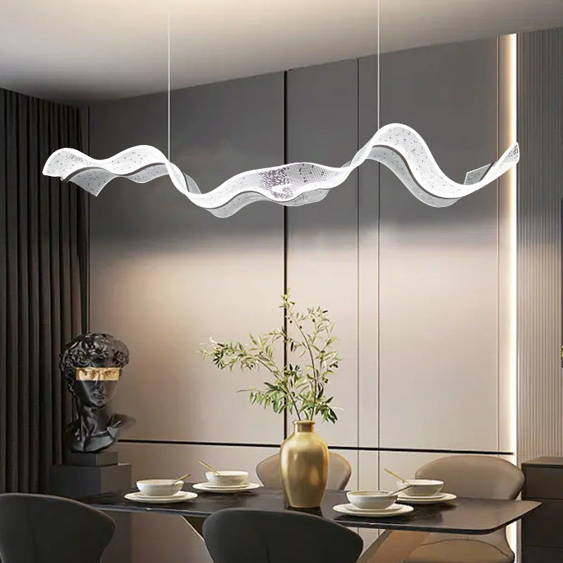 Elegante moderne Pendelleuchte aus goldfarbenem Metall, hängend über einem stilvollen Esstisch im Esszimmer.