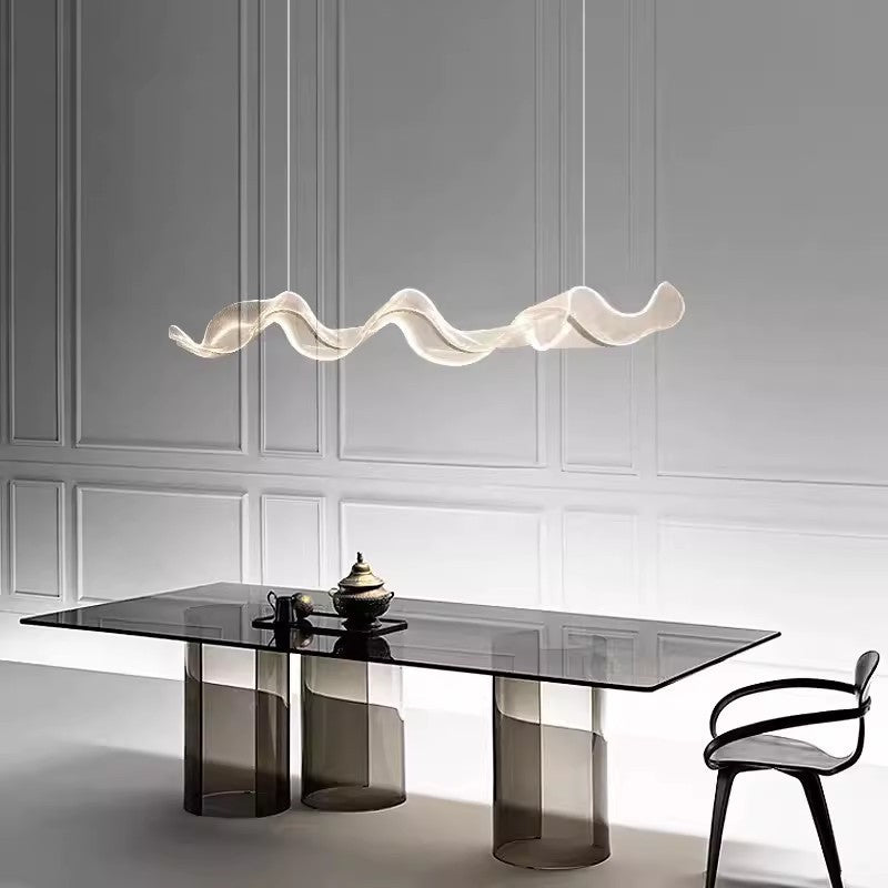Goldene Metall-Pendelleuchte über einem gedeckten Esstisch, die warmes Licht in das moderne Esszimmer bringt.
