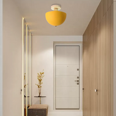 Helle gelbe Deckenleuchte mit Holzsockel, an der Decke montiert, schafft eine warme und freundliche Atmosphäre.