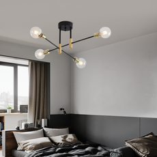 Moderne LED-Deckenleuchte in Gold als stilvoller Blickfang über dem Bett in einem gemütlich eingerichteten Schlafzimmer.