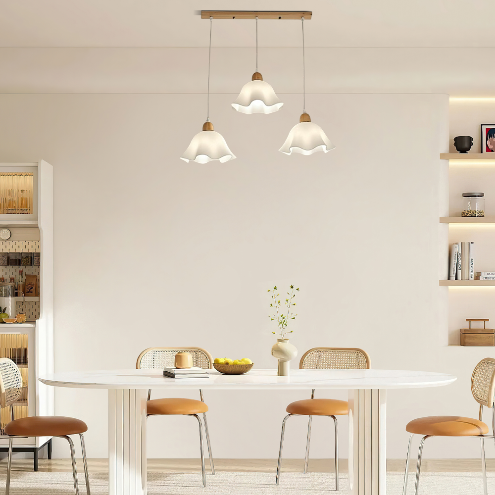Dreiflammige Pendelleuchte mit weißen Blütenschirmen und Holzdetails elegant über einem langen Esstisch arrangiert
