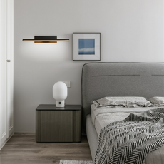 Schwenkbare LED-Wandleuchte mit drehbarem Leuchtkörper über dem Betthaupt in einem hellen Schlafzimmer